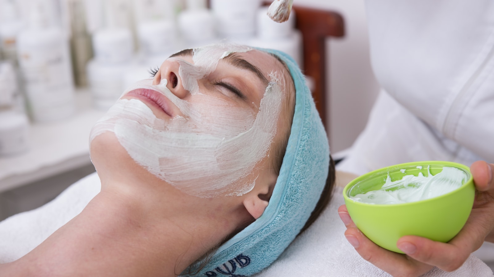 Productos profesionales para tratamiento facial post-verano: sérum hidratante, rodillo de jade, brochas y toallas en salón de belleza